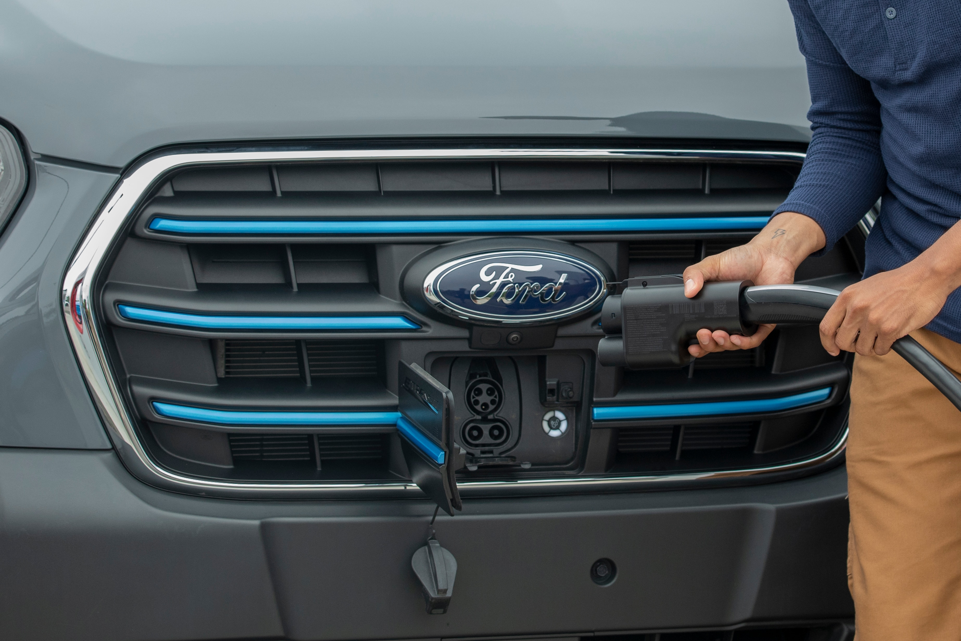 A charger adapter is shown near the charging port of a Ford electric vehicle.